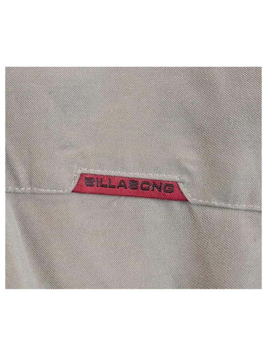 Close-up of a beige BillaBong Hawaiian shirt featuring a small red brand label from JAKE & IPI
