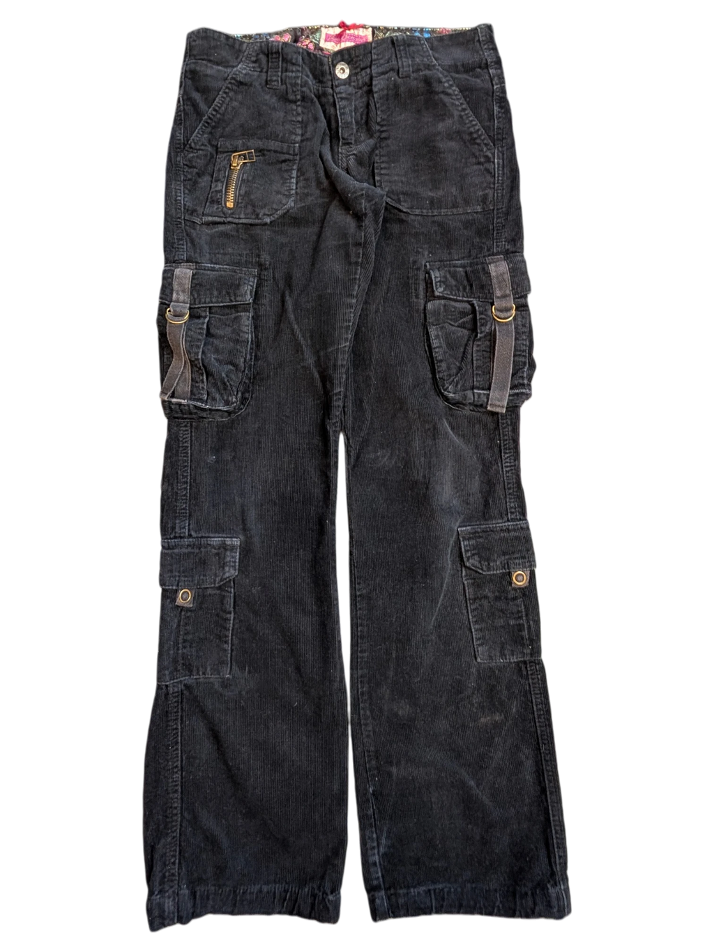 JAKE & IPI black corduroy cargo pants with multiple pockets, zip details, and adjustable straps.