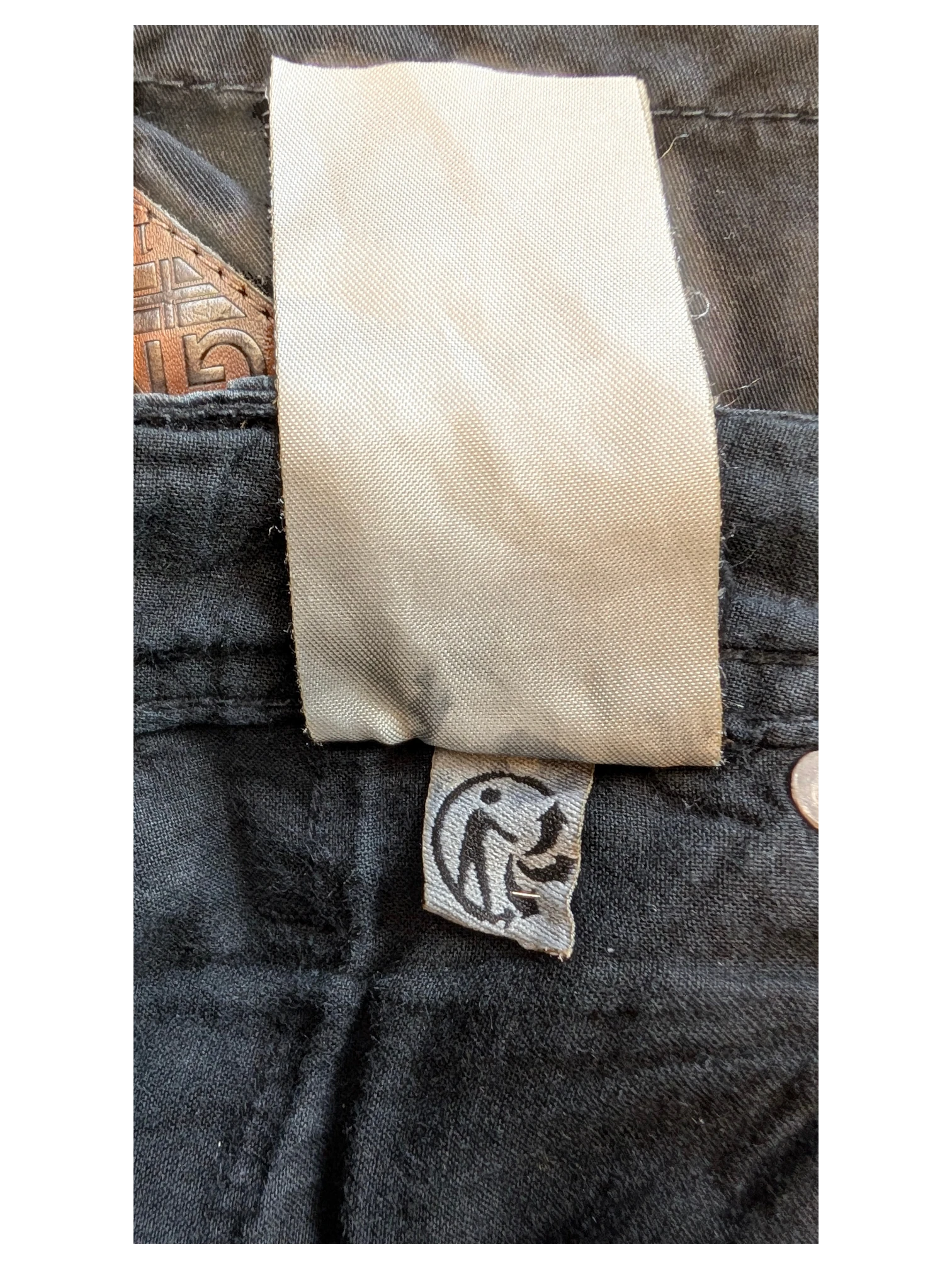 JAKE & IPI black cotton blend trousers with a woven label and a small tag featuring a circular logo.