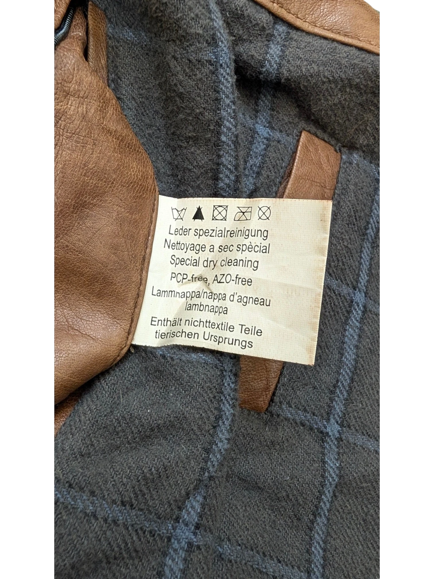 JAKE & IPI brown leather jacket with grey plaid lining and care label.