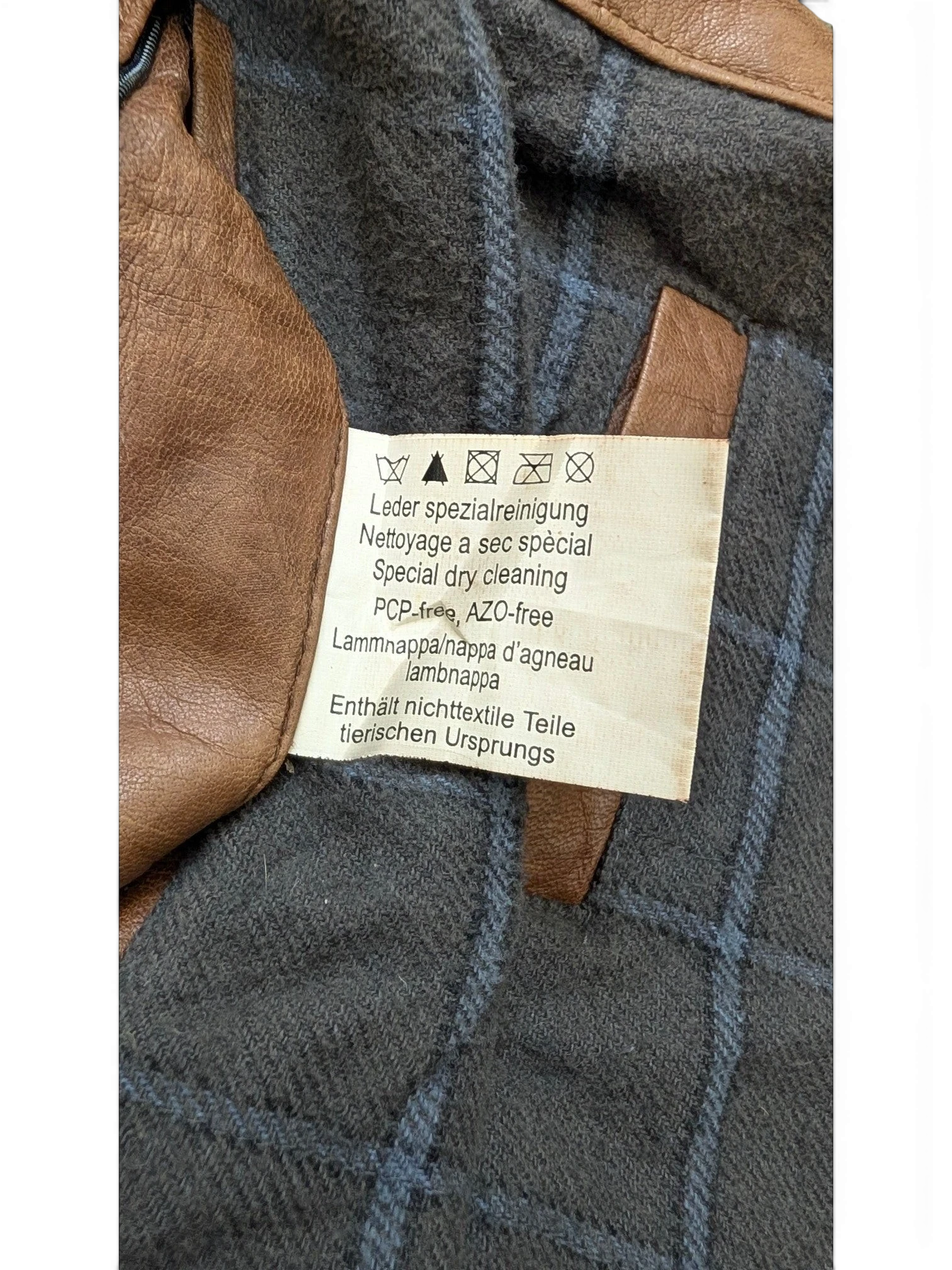 JAKE & IPI brown leather jacket with grey plaid lining and care label.