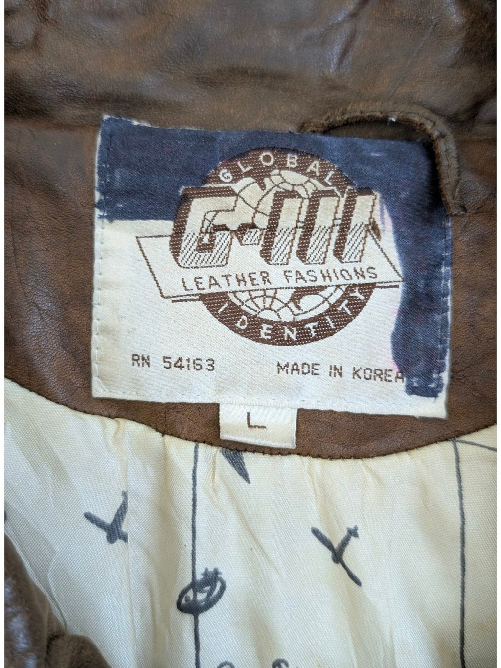 JAKE & IPI brown leather jacket with "G-III LEATHER FASHIONS" label and unique map print lining.