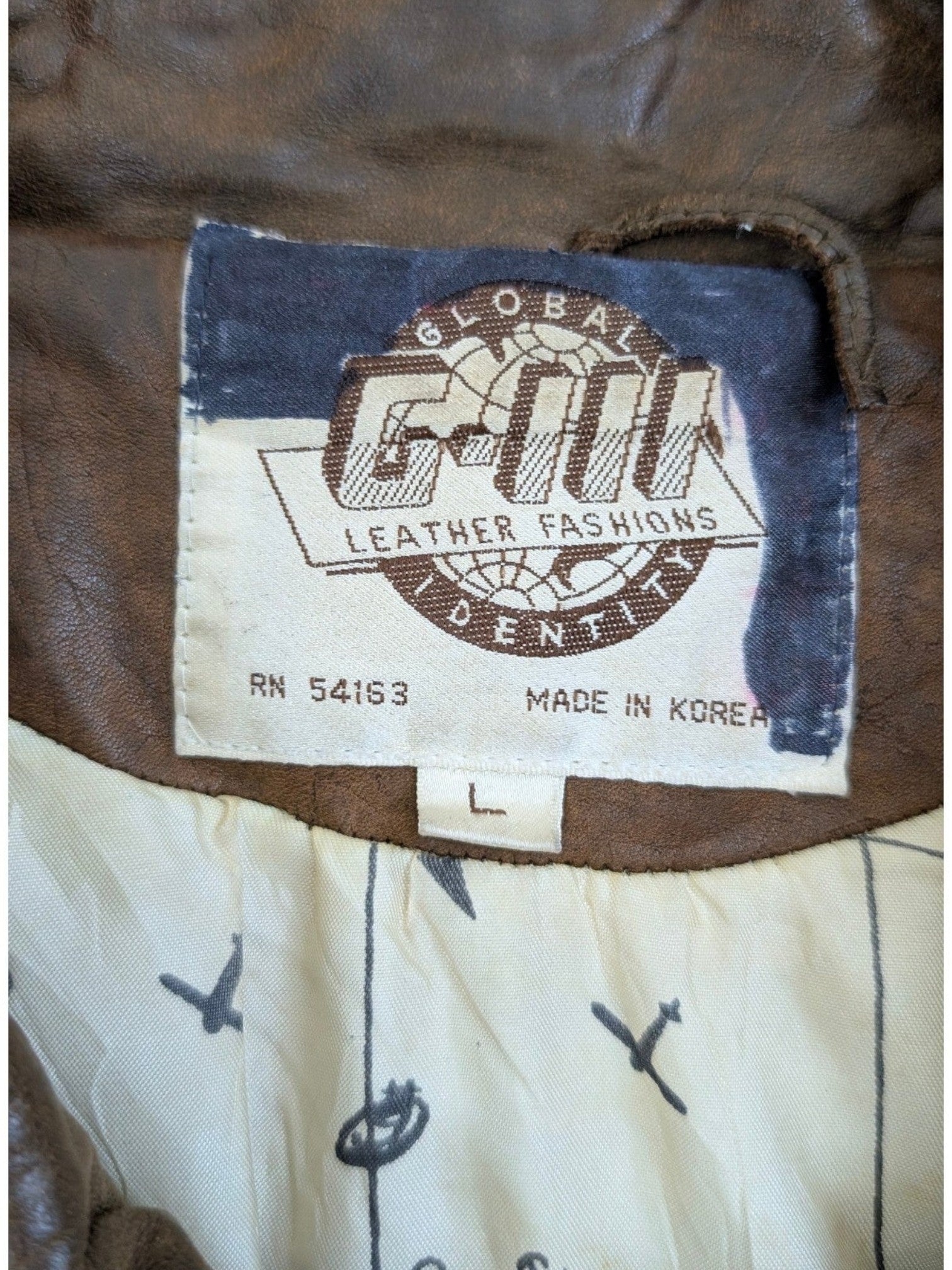 JAKE & IPI brown leather jacket with "G-III LEATHER FASHIONS" label and unique map print lining.