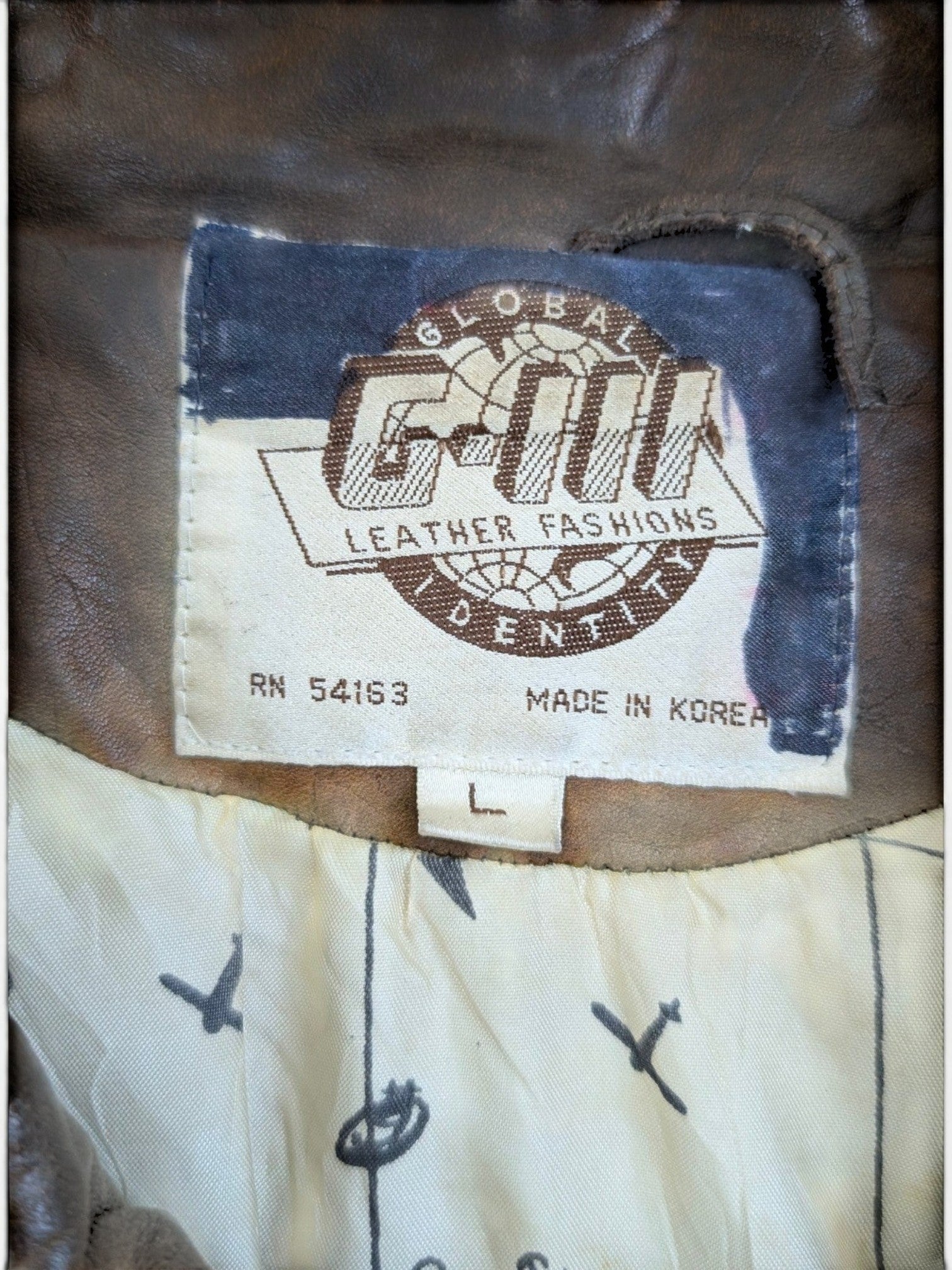 JAKE & IPI brown leather jacket with "G-III LEATHER FASHIONS" label and unique map print lining.