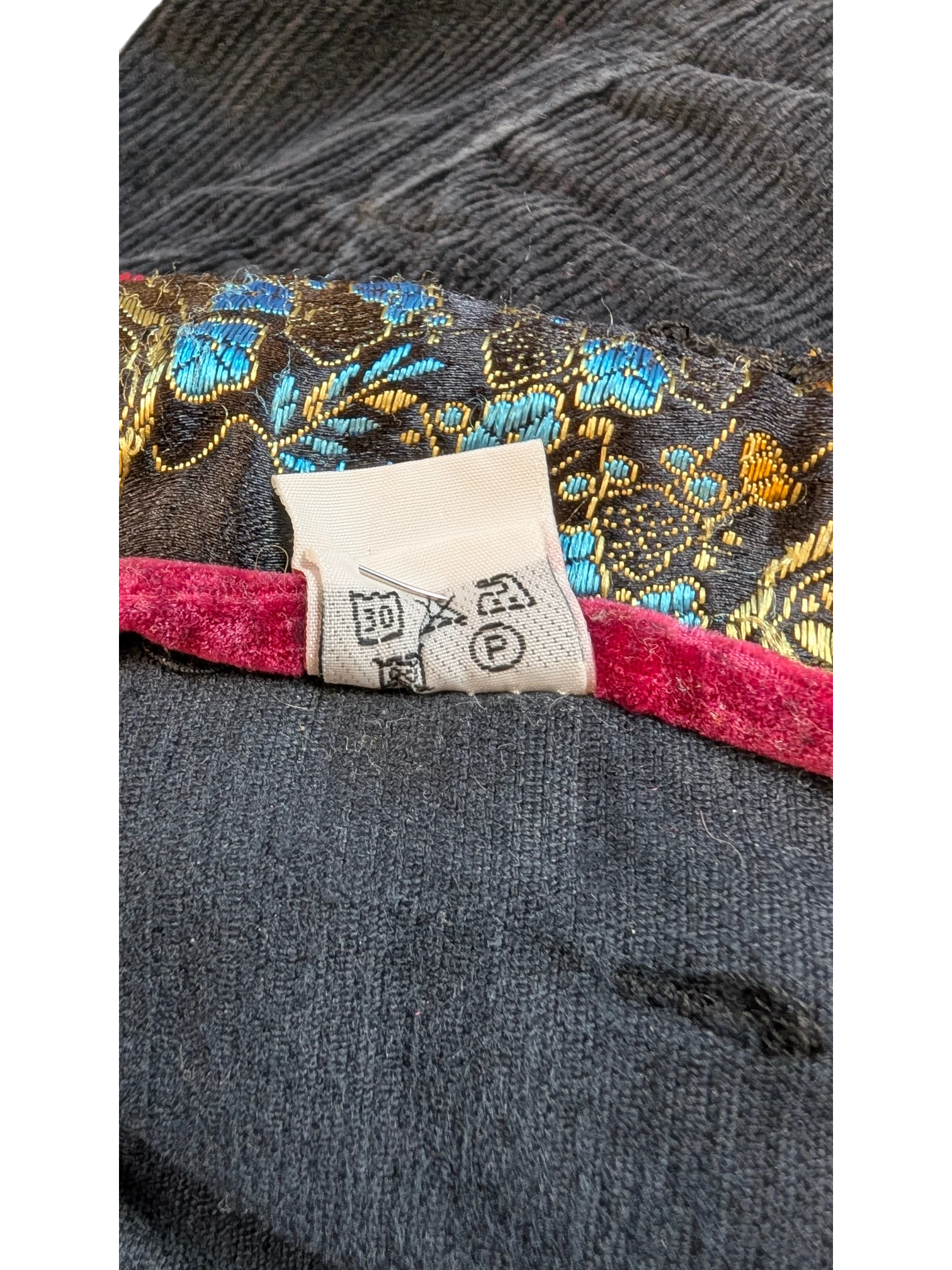 JAKE & IPI dark grey corduroy cargo pants with ornate floral lining and care tag.
