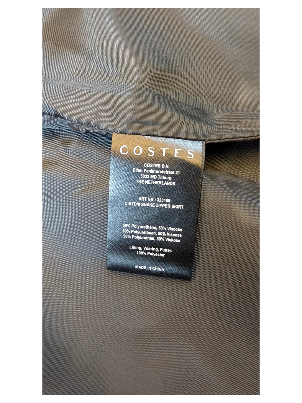 JAKE & IPI Costes faux leather mini skirt care label showing material composition of polyurethane and viscose.