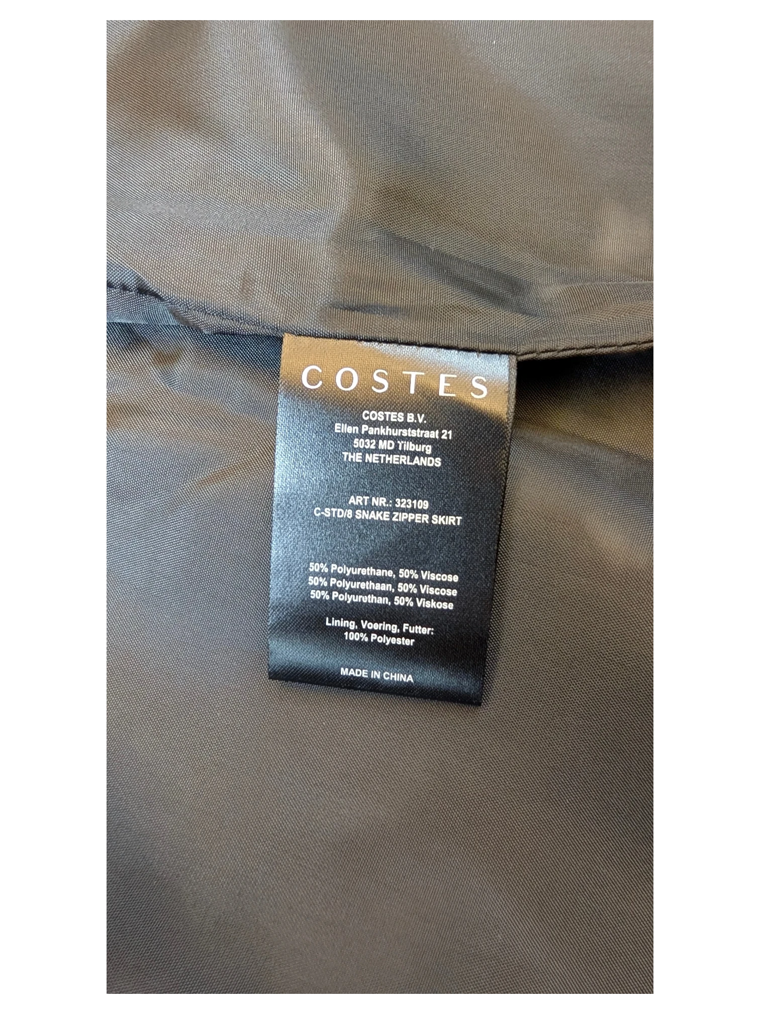 JAKE & IPI Costes faux leather mini skirt care label showing material composition of polyurethane and viscose.