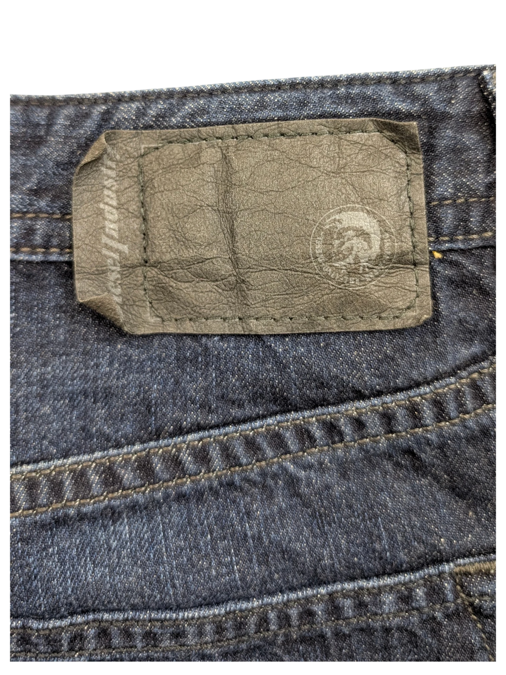 JAKE & IPI dark wash denim jeans with a black leather Diesel Industries patch on the back.