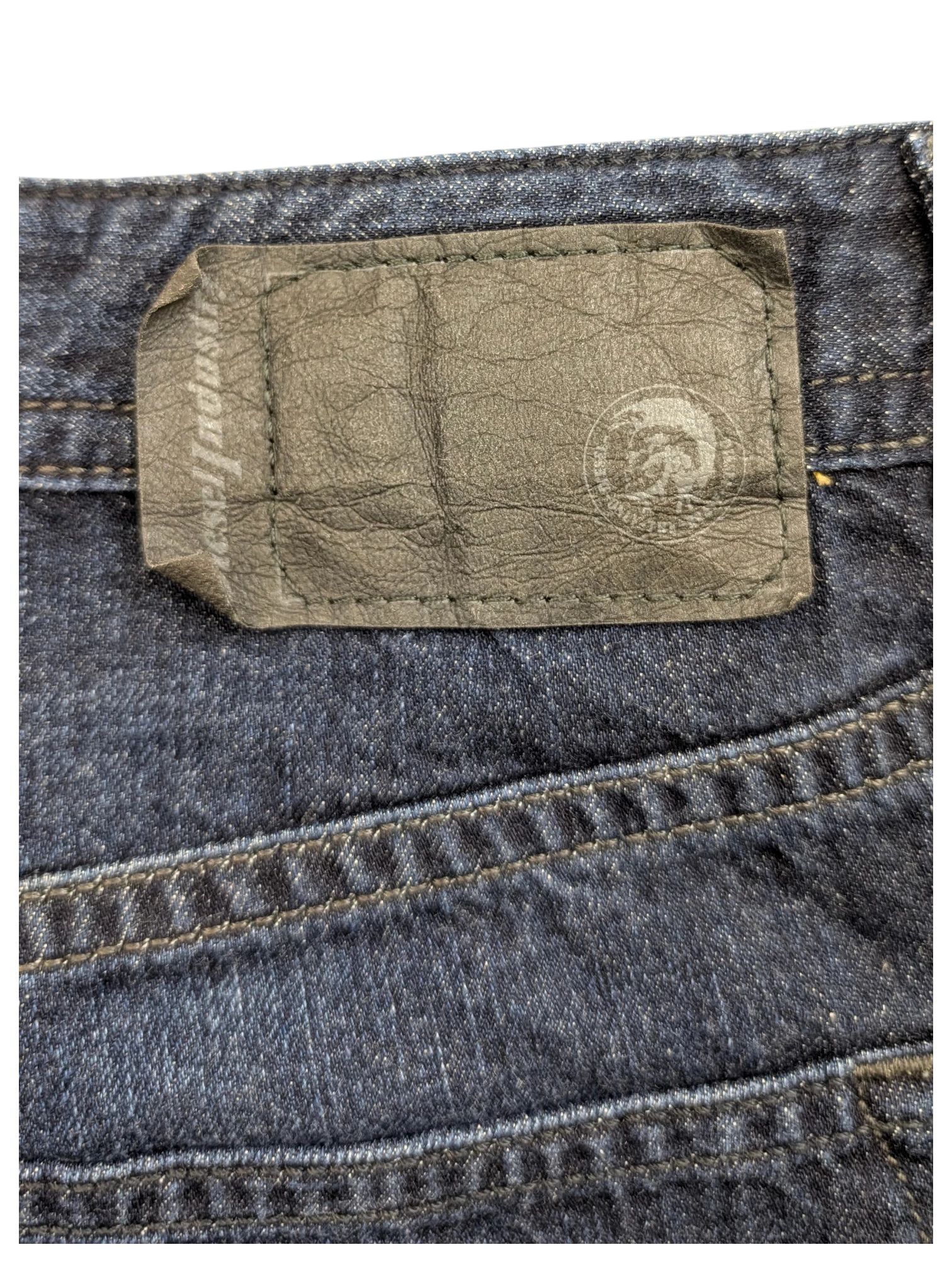JAKE & IPI dark wash denim jeans with a black leather Diesel Industries patch on the back.
