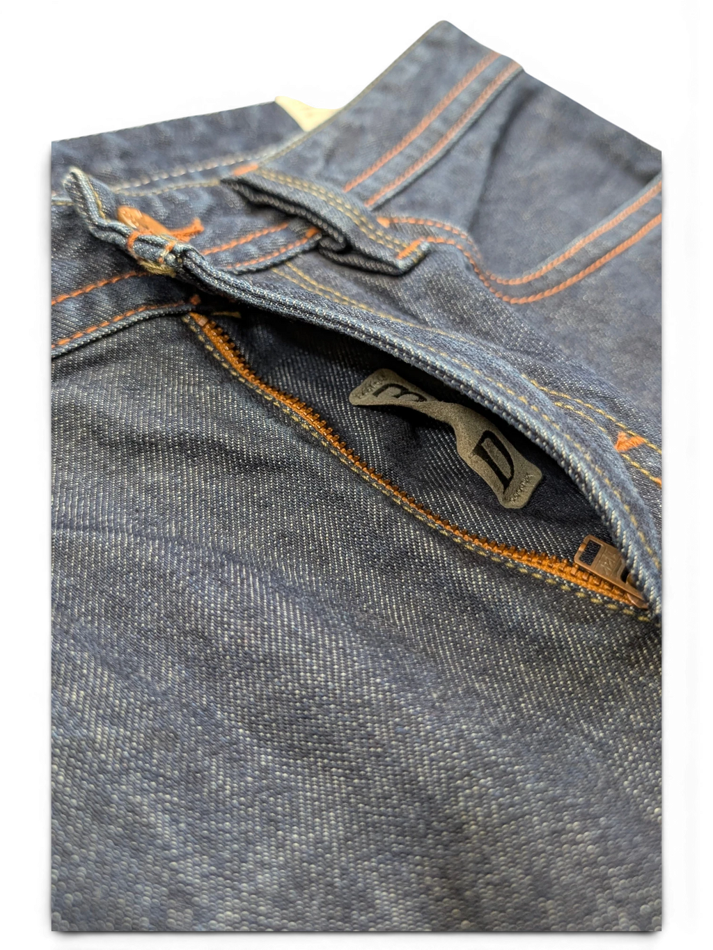 JAKE & IPI dark wash denim jeans with orange stitching and a zip pocket detail.