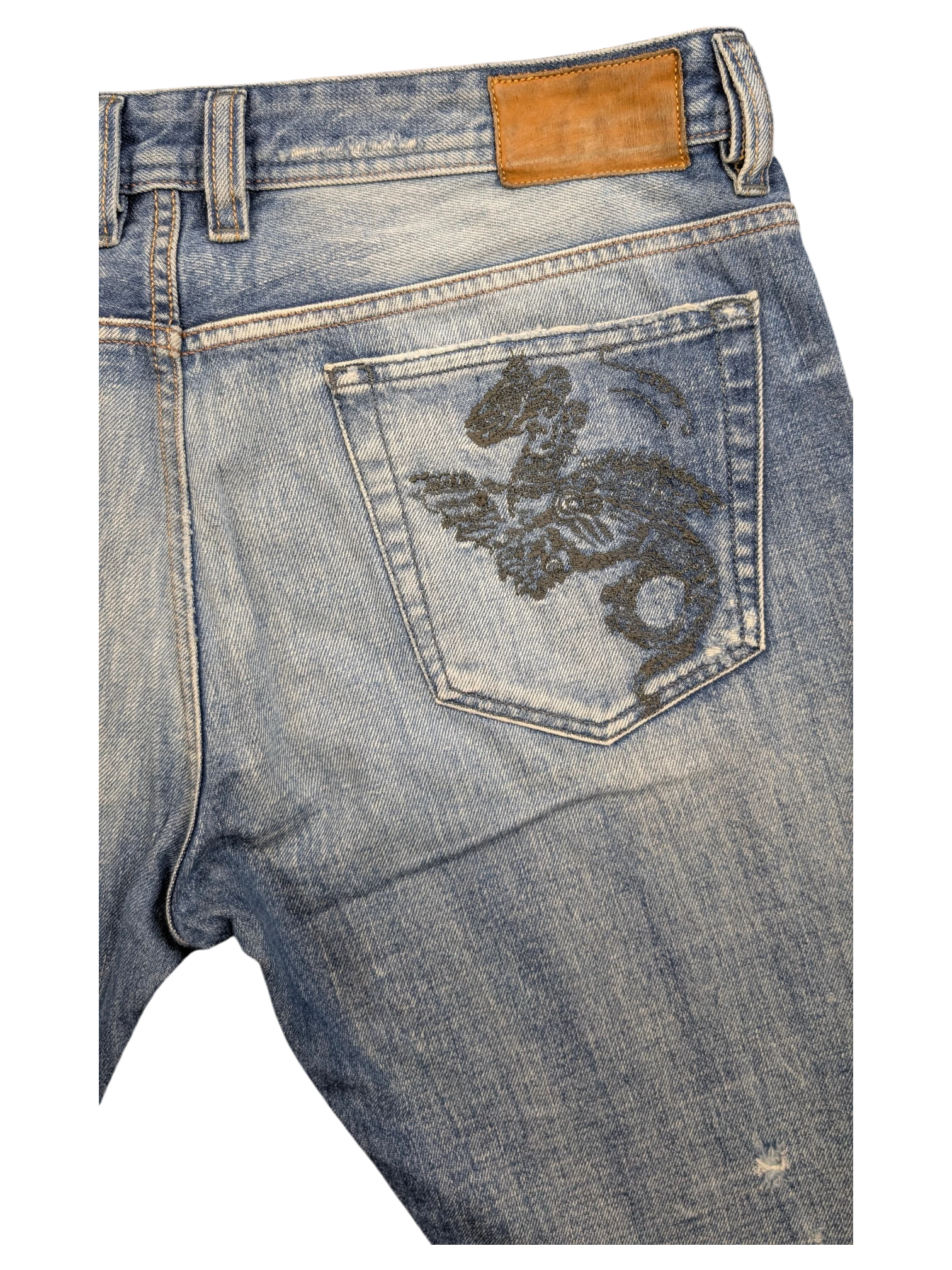 JAKE & IPI light wash denim jeans with a black dragon embroidered on the back pocket and a brown leather patch.