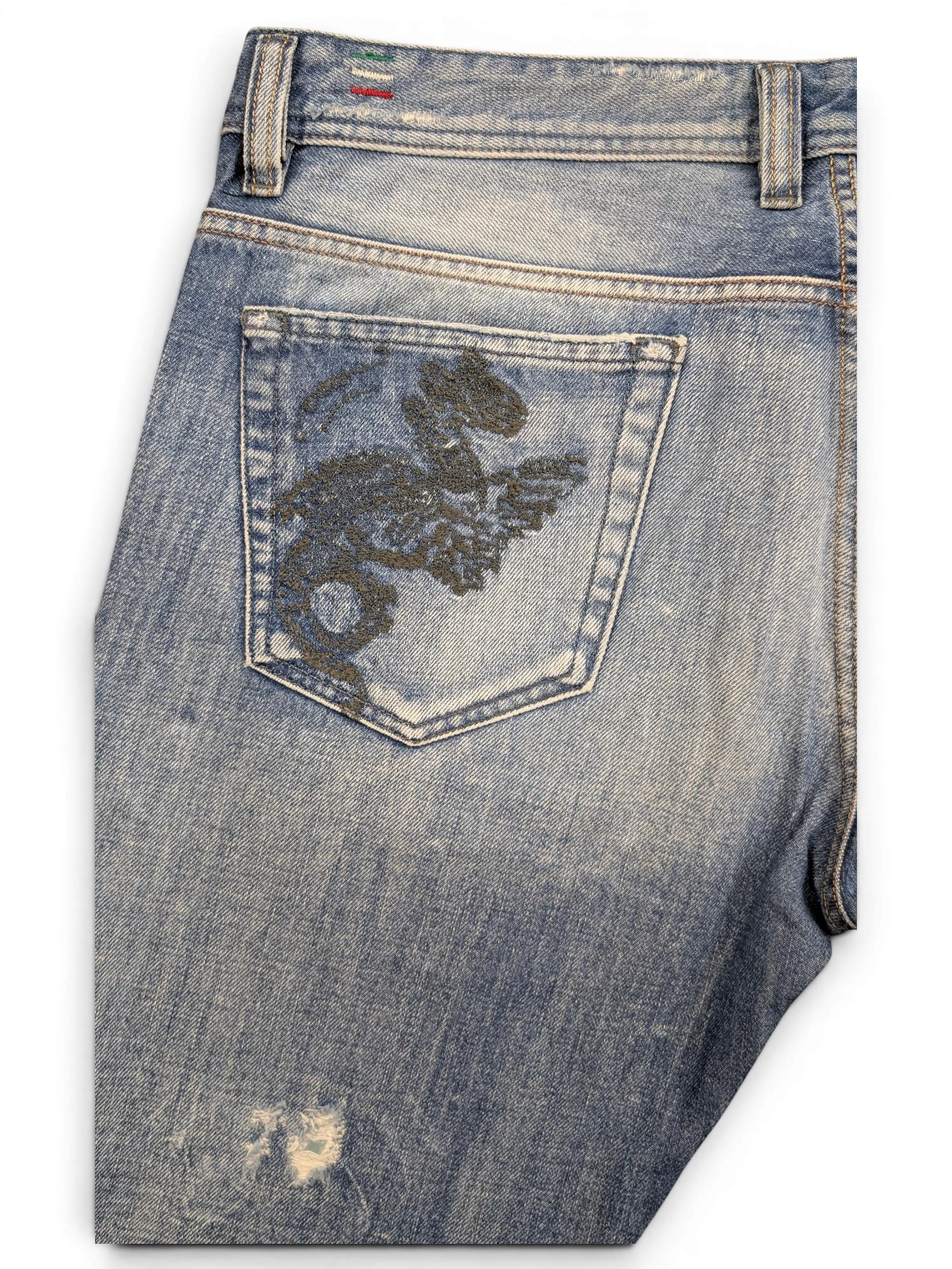 JAKE & IPI light wash denim jeans with embroidered dragon on back pocket and distressed detail.