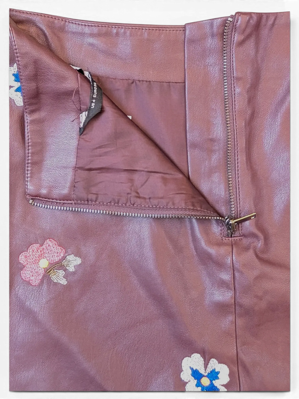 JAKE & IPI burgundy faux leather mini skirt with floral embroidery and side zipper closure.