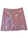 JAKE & IPI mauve faux leather mini skirt featuring delicate multi-colored floral embroidery throughout.