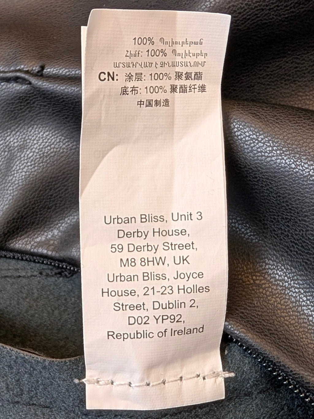 JAKE & IPI Urban Bliss black faux leather mini skirt care label showing 100% polyester composition