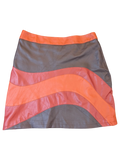 JAKE & IPI mini skirt in faux leather featuring a wavy paneled design in vibrant orange and dark grey tones.