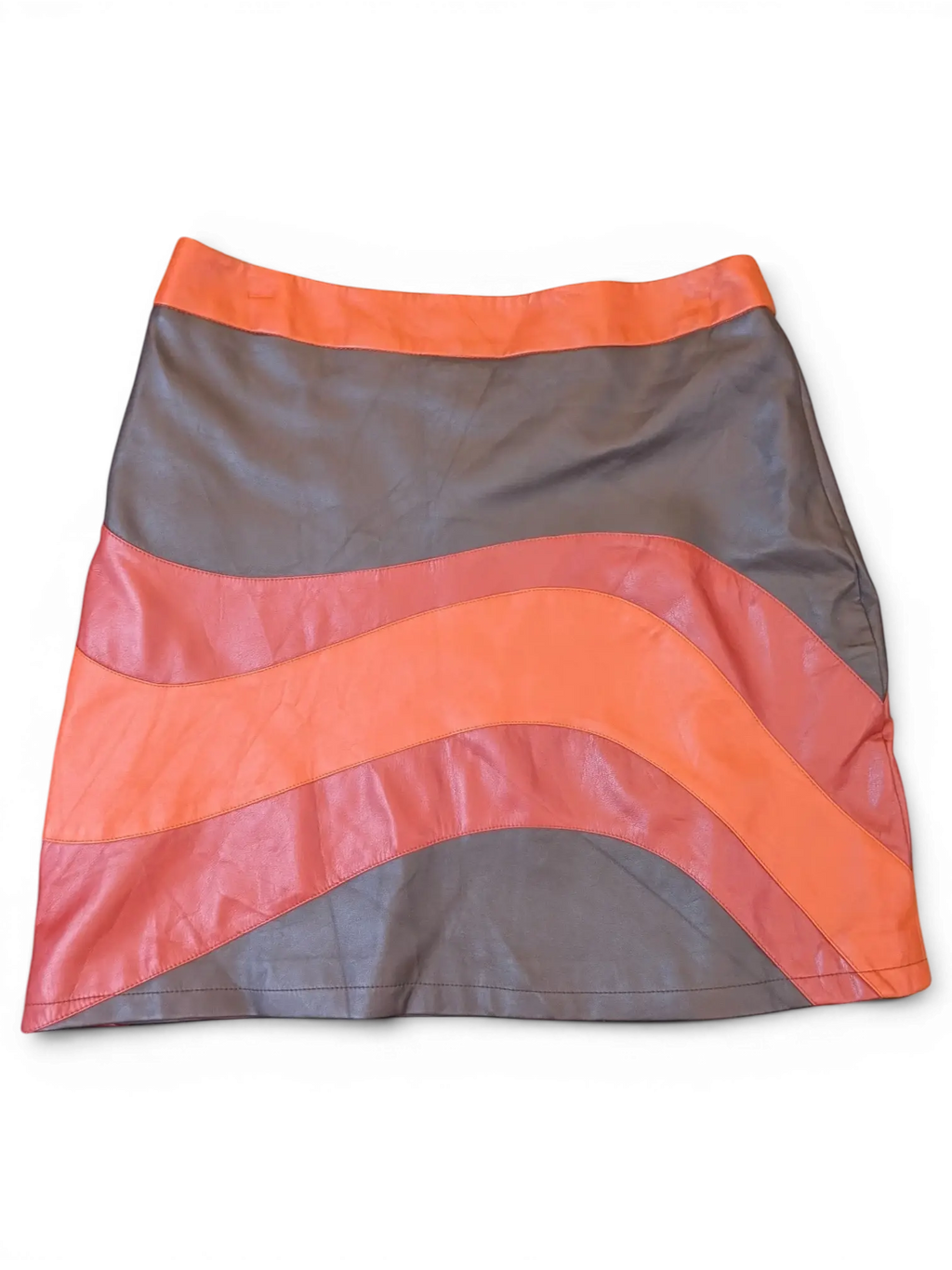 JAKE & IPI mini skirt in faux leather featuring a wavy paneled design in vibrant orange and dark grey tones.