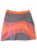 JAKE & IPI mini skirt in faux leather featuring a wavy paneled design in vibrant orange and dark grey tones.
