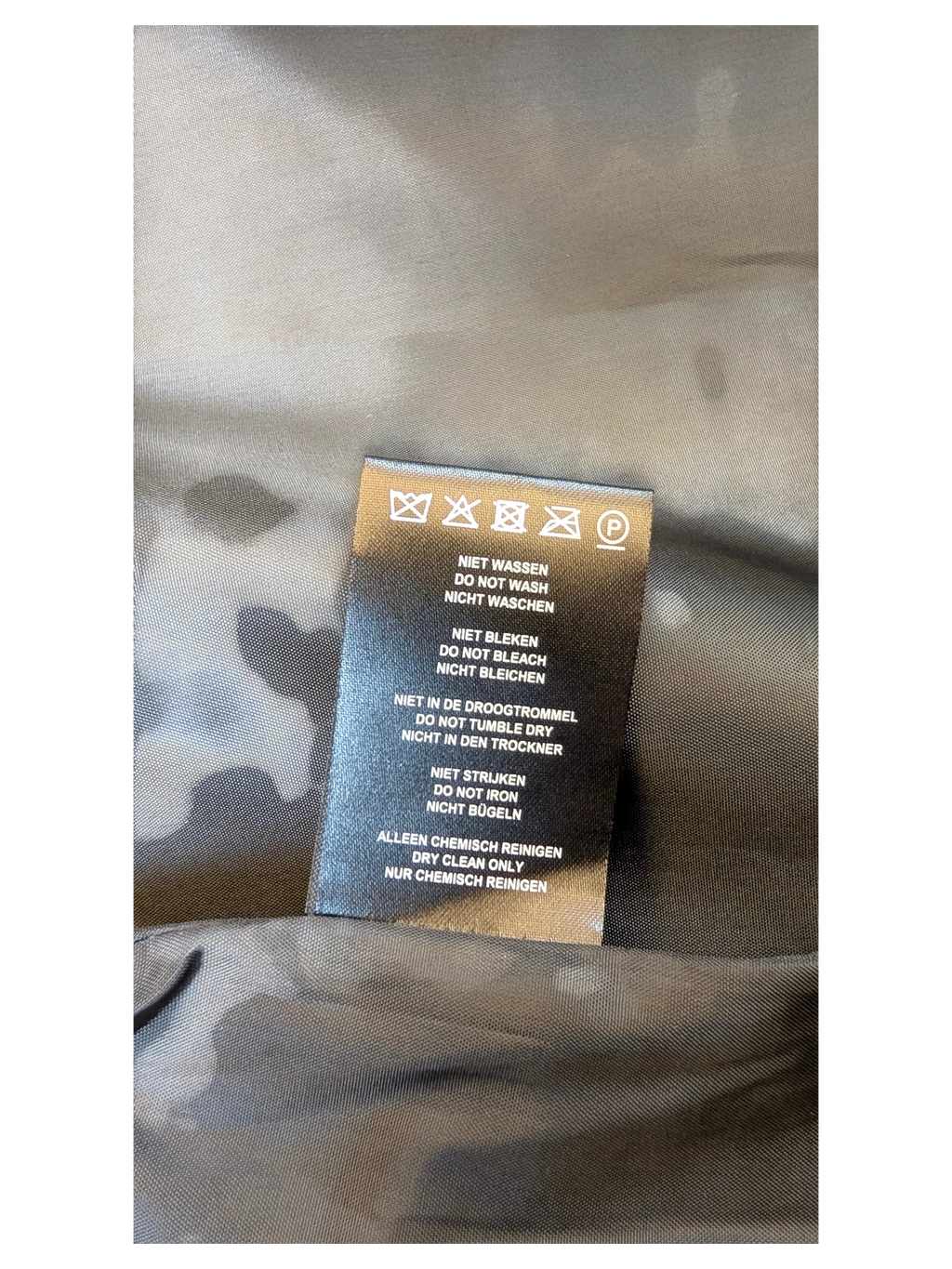 JAKE & IPI Costes faux leather mini skirt care label with dry clean only instructions on black fabric