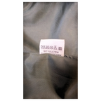 Care label for JAKE & IPI Staccato faux leather midi skirt with cleaning instructions in German.