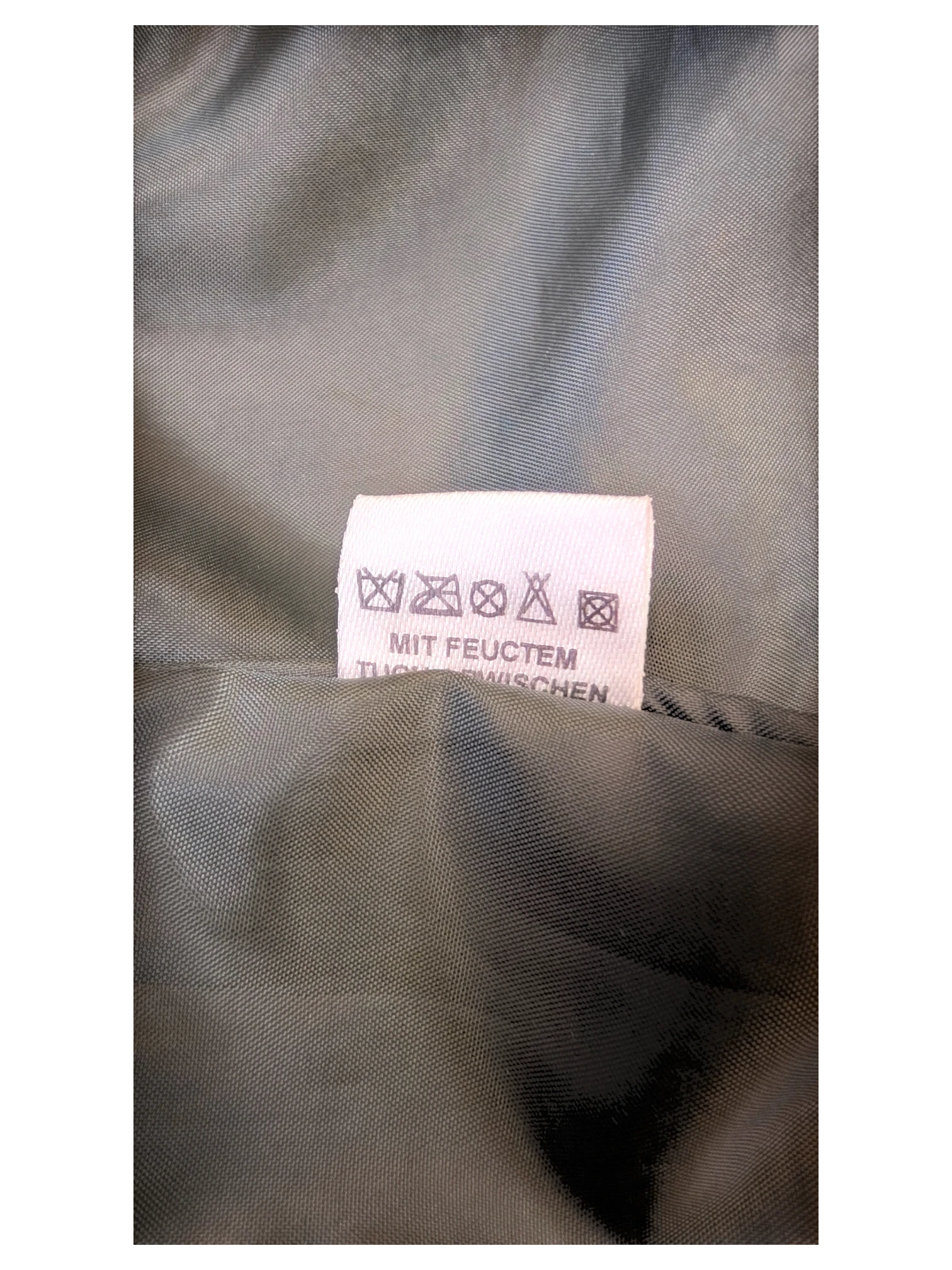 Care label for JAKE & IPI Staccato faux leather midi skirt with cleaning instructions in German.
