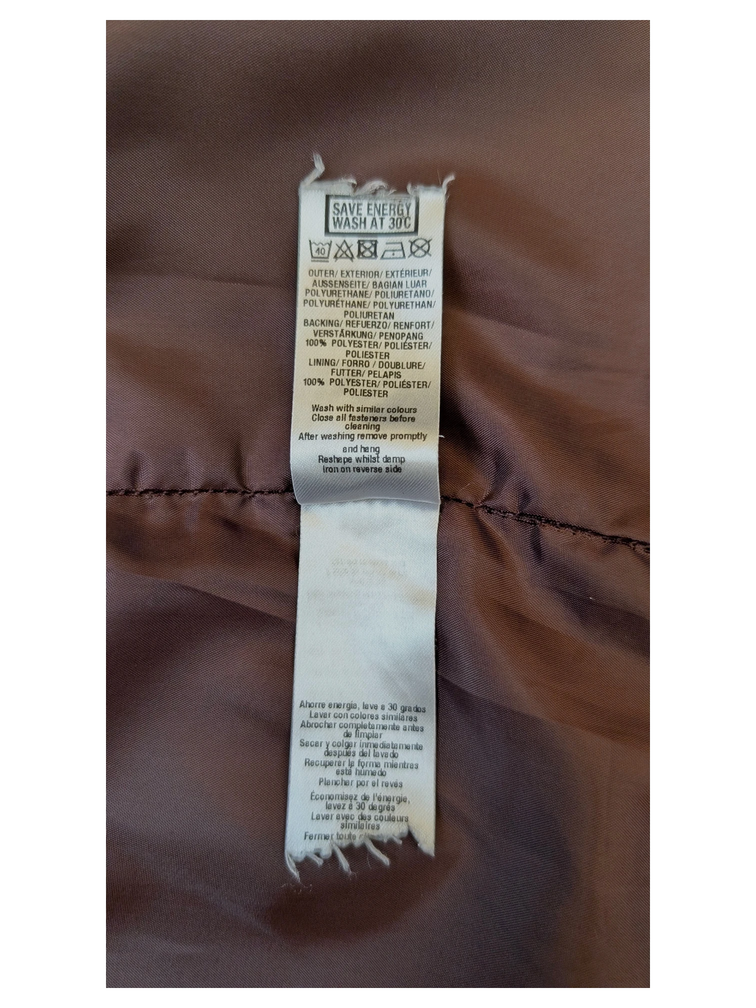JAKE & IPI faux leather mini skirt care label showing polyurethane material and polyester lining details.