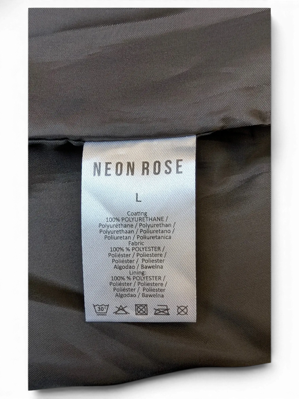 JAKE & IPI Neon Rose faux leather mini skirt care label showing 100% polyurethane coating and polyester lining