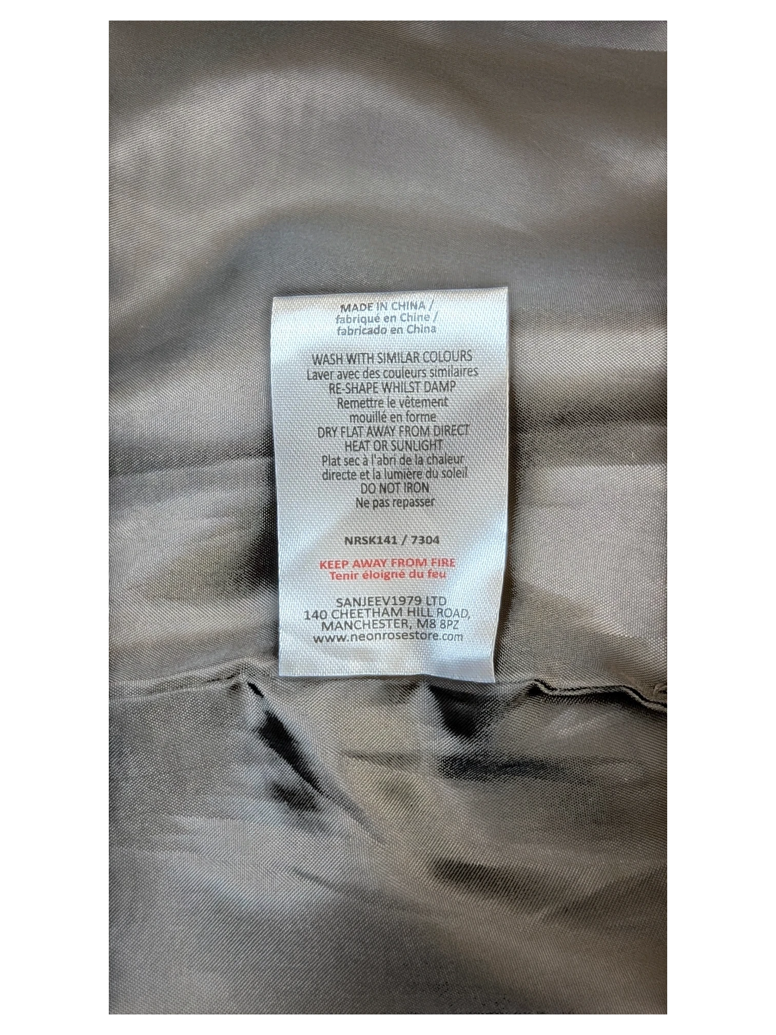 JAKE & IPI care label for Neon Rose paneled faux leather mini skirt with washing instructions and fabric details.