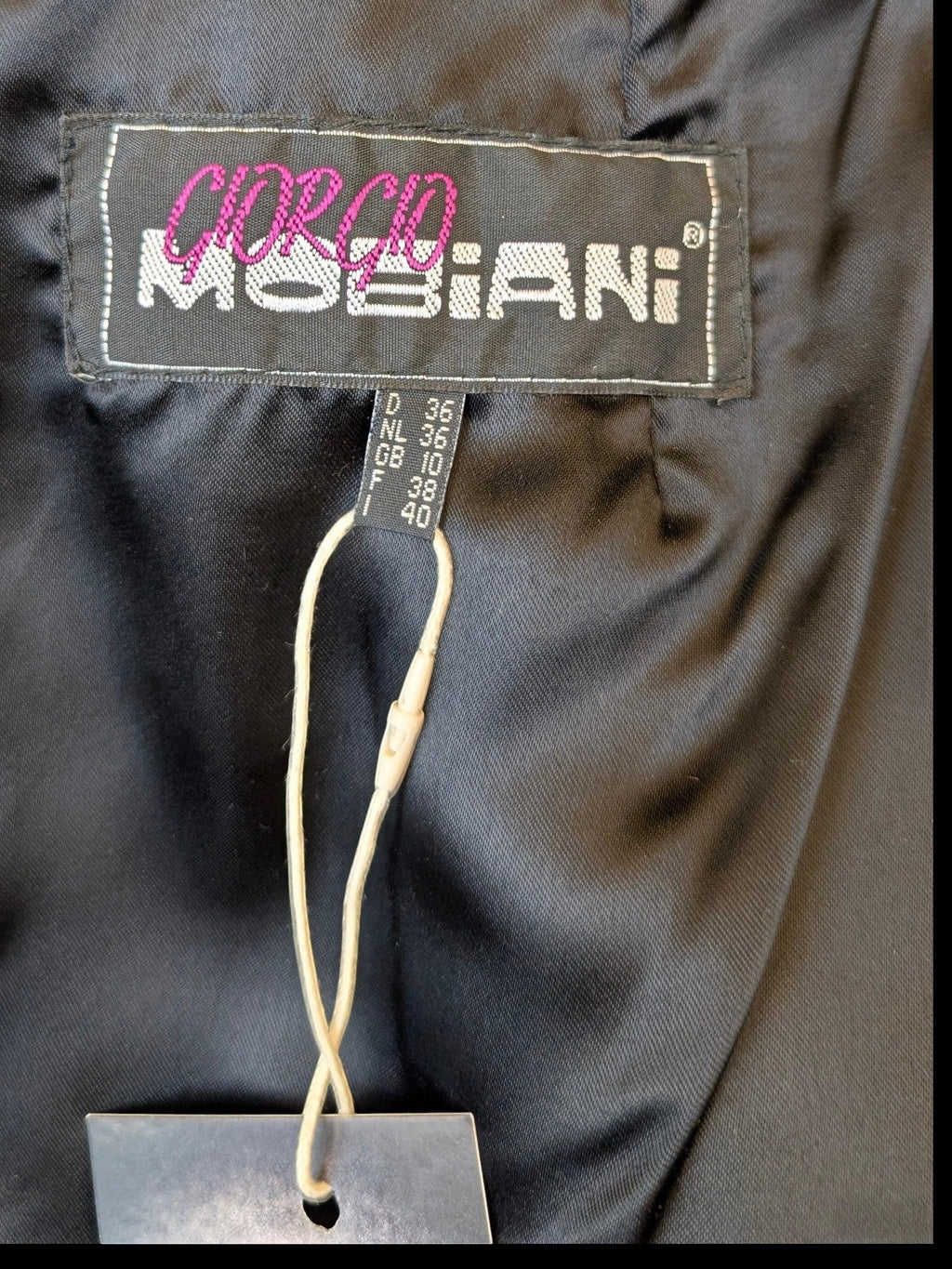 Giorgio Mobiani black leather skirt label and size tag from JAKE & IPI, featuring smooth lining and button detail.