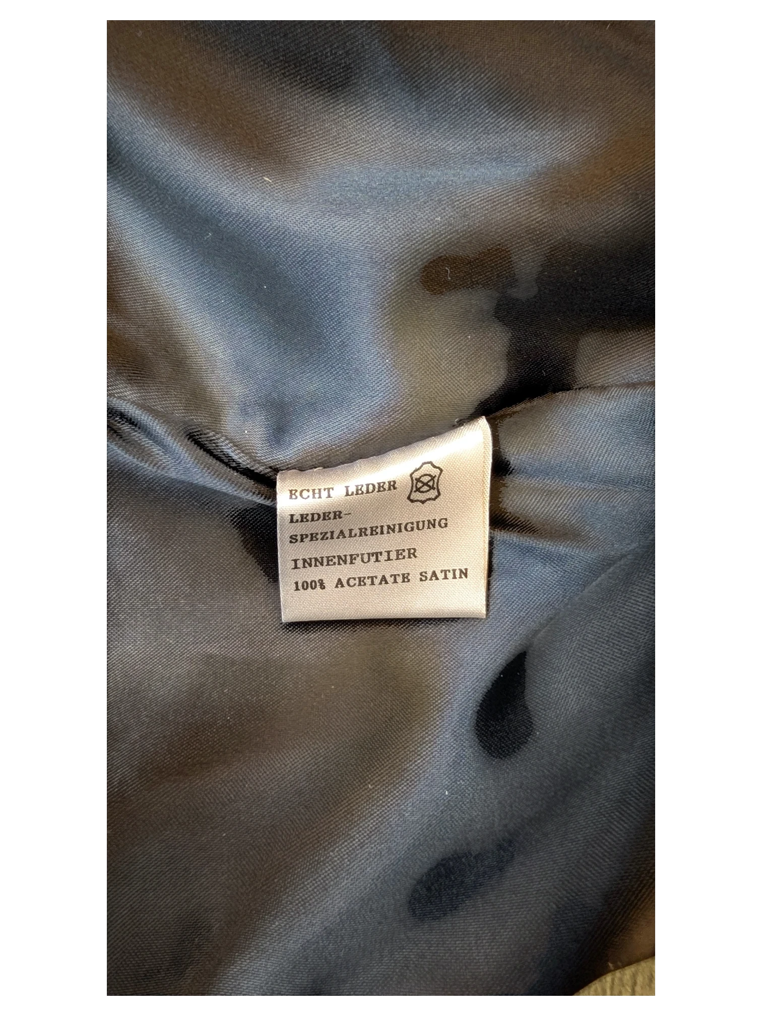 JAKE & IPI Giorgio Mobiani leather skirt care label showing 100% acetate satin lining and genuine leather material