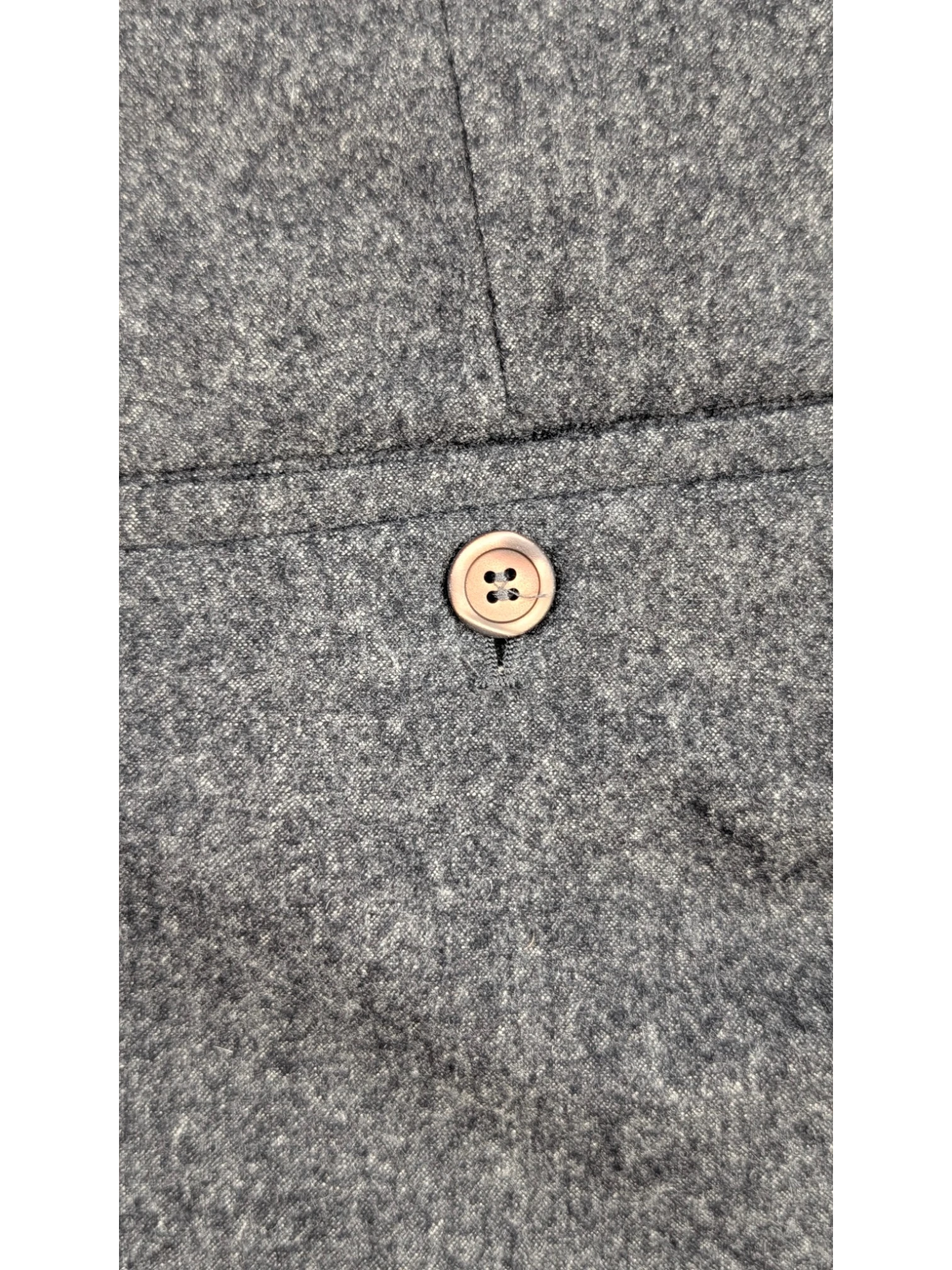 JAKE & IPI grey mélange wool blend flannel tailored trousers with horn-style button detail.
