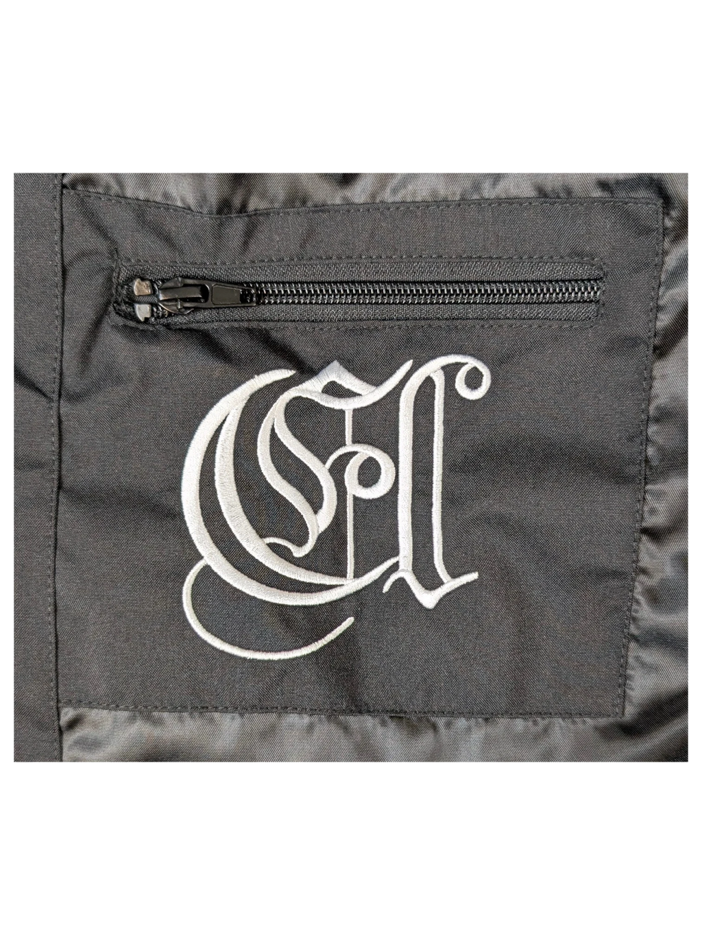 JAKE & IPI IBE Elenyor jacket black fabric with white embroidered gothic logo and zippered pocket detail