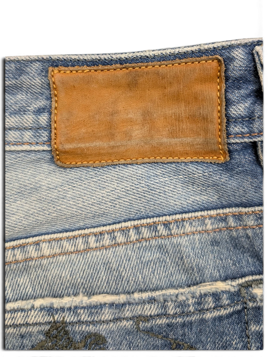 JAKE & IPI light wash denim jeans with brown leather patch and distressed details. W36 L34.
