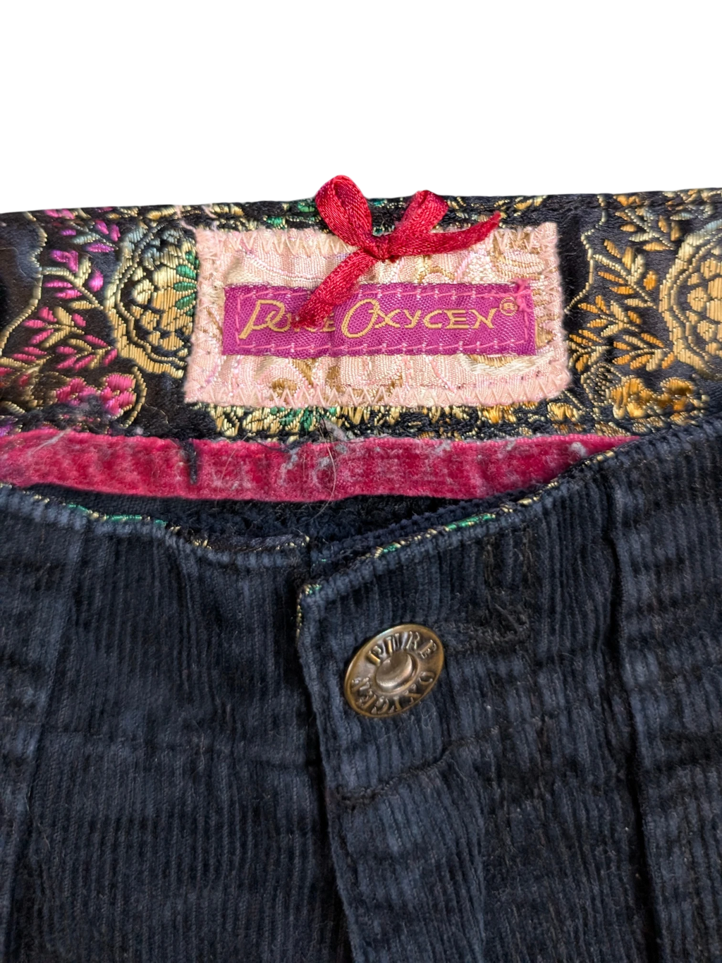 JAKE & IPI Pure Oxygen navy blue corduroy cargo pants with ornate lining and red bow detail.
