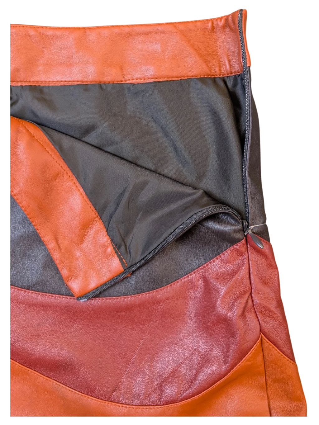 JAKE & IPI paneled faux leather mini skirt in orange, brown, and red with a side zipper and dark lining.