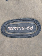 JAKE & IPI Route 66 -nahkatakki kulutetun ruskeana brodeeratulla soikealla merkillä.