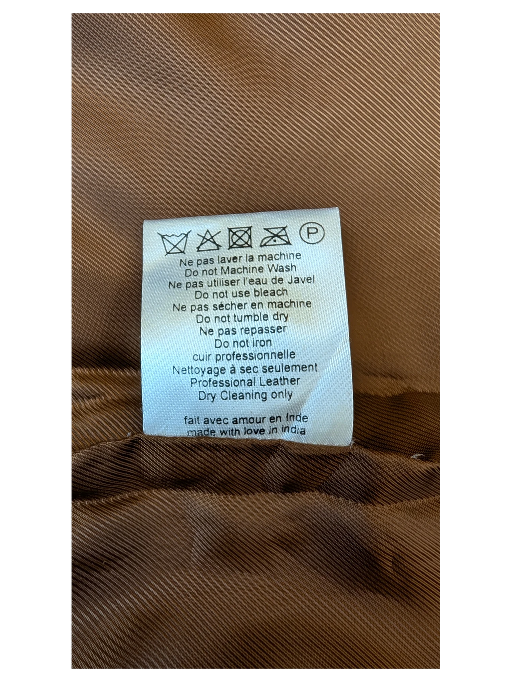 JAKE & IPI Sézane leather skirt care label with professional dry cleaning instructions on brown fabric lining.