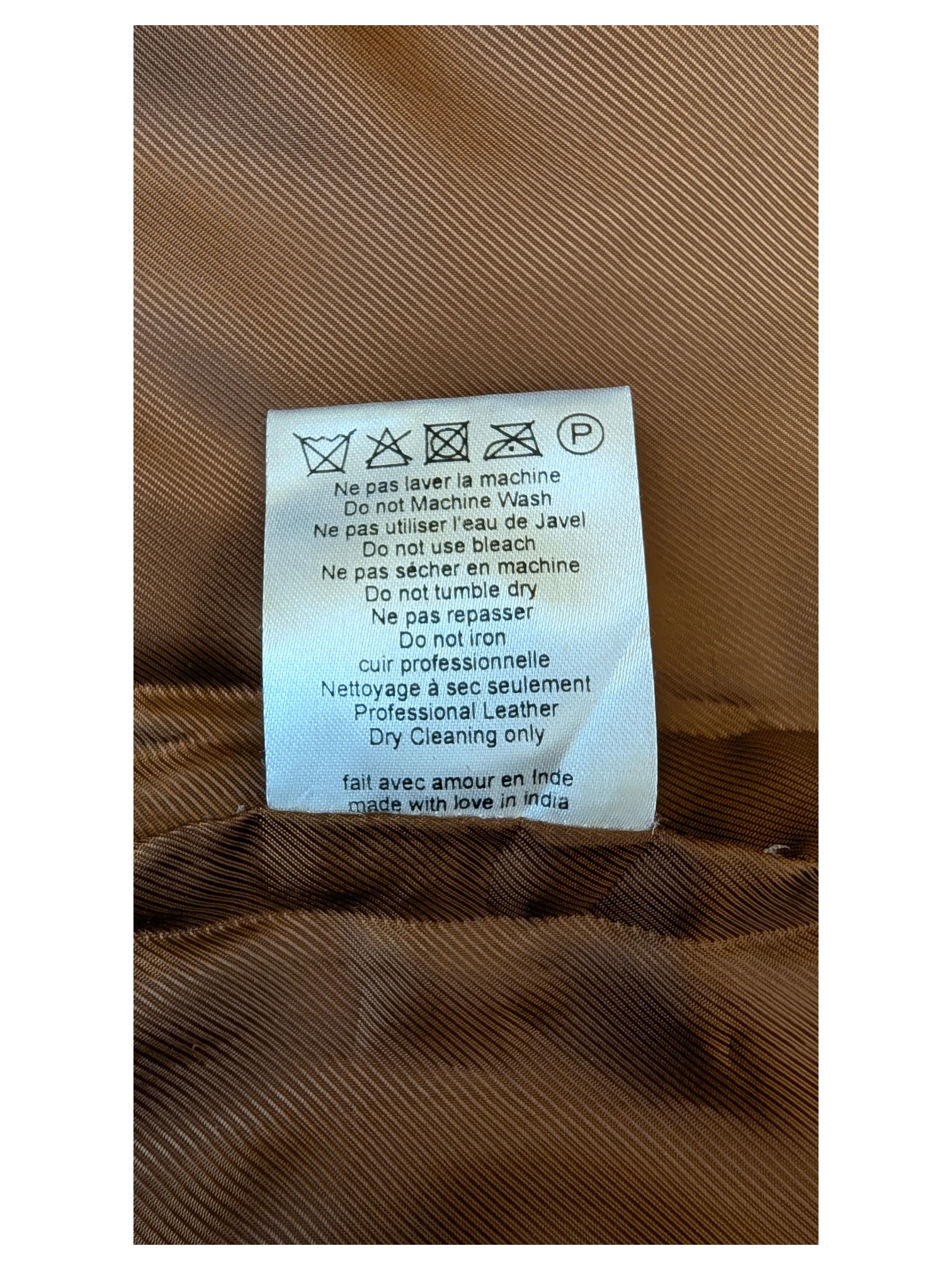 JAKE & IPI Sézane leather skirt care label with professional dry cleaning instructions on brown fabric lining.