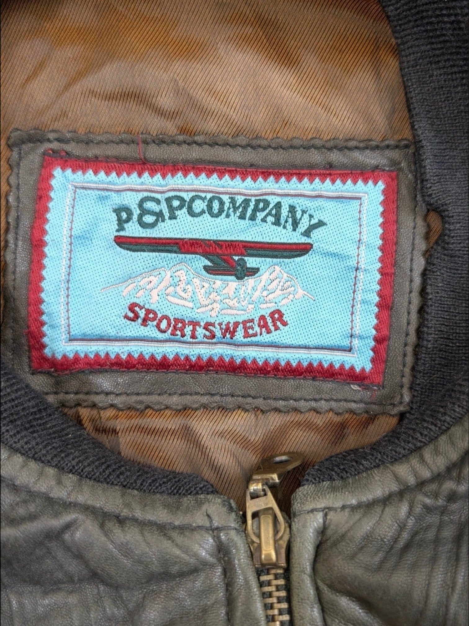 JAKE & IPI P&P COMPANY sportswear leather jacket in olive green with a distressed finish and brass zipper.