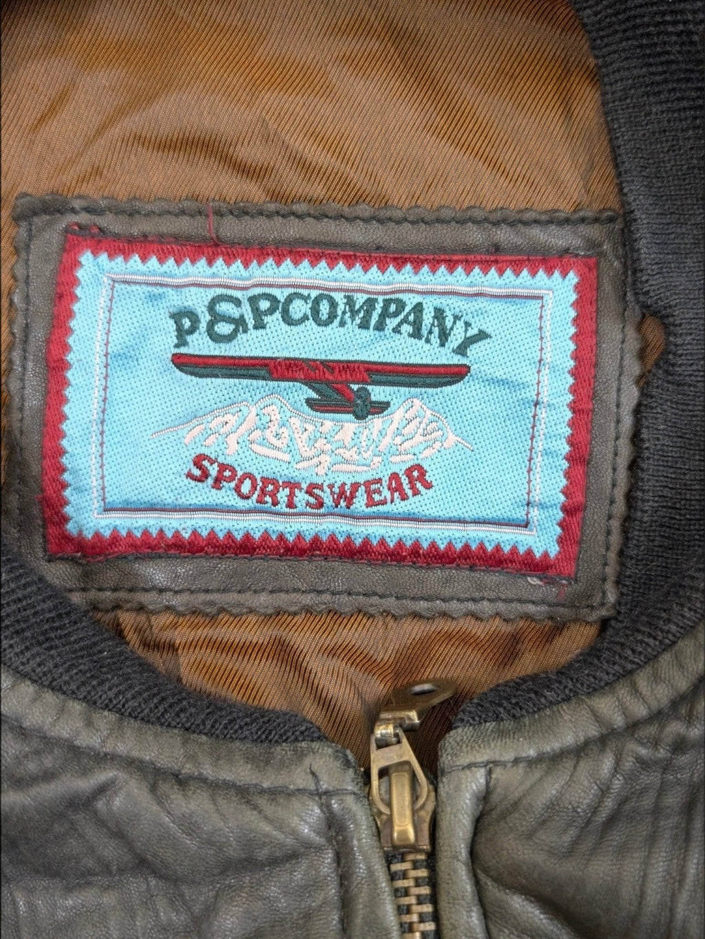 JAKE & IPI P&P COMPANY sportswear leather jacket in olive green with a distressed finish and brass zipper.