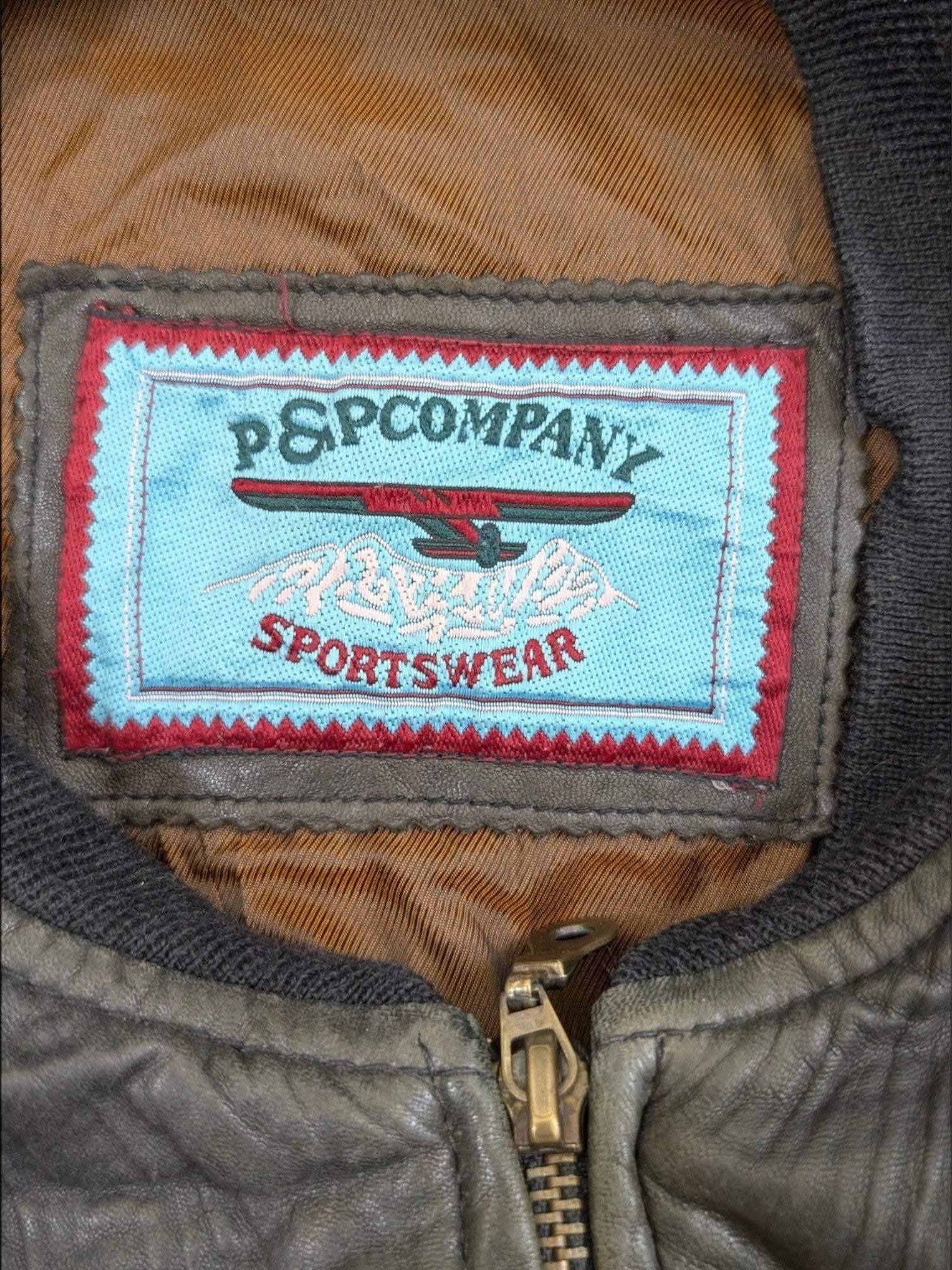 JAKE & IPI P&P COMPANY sportswear leather jacket in olive green with a distressed finish and brass zipper.