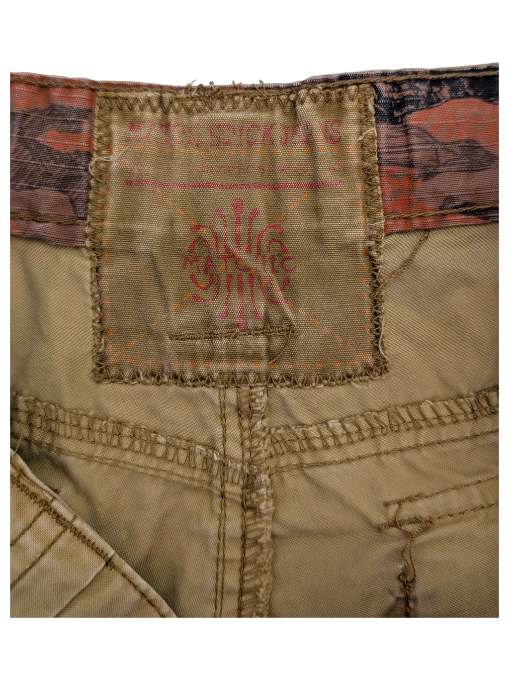 JAKE & IPI tan cargo pants with a distressed logo patch and camouflage waistband detail.