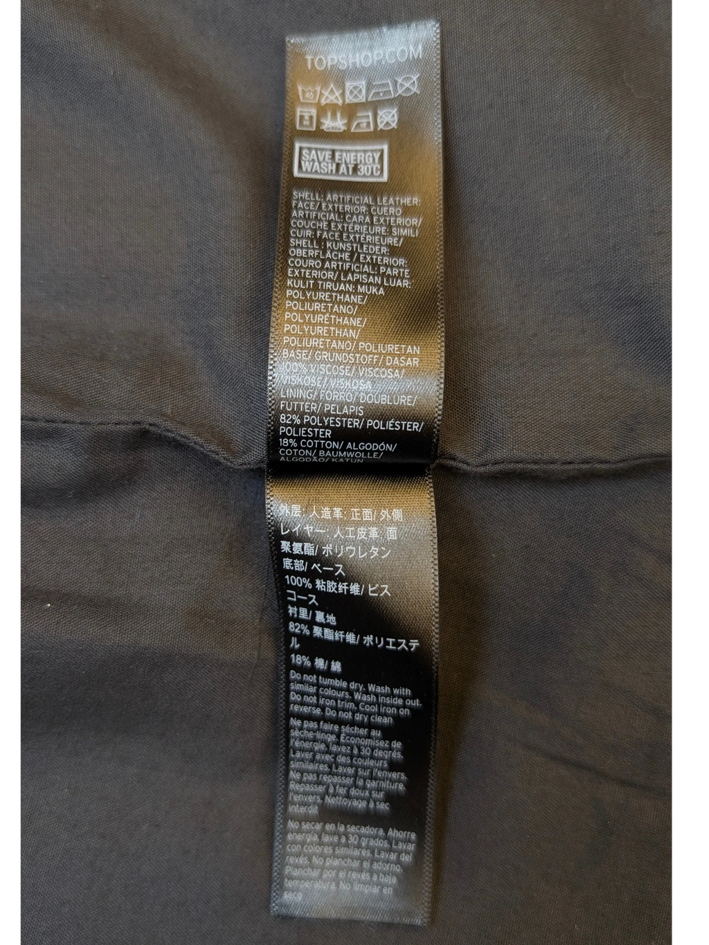 TOPSHOP black faux leather mini skirt care label from JAKE & IPI showing material composition and washing instructions