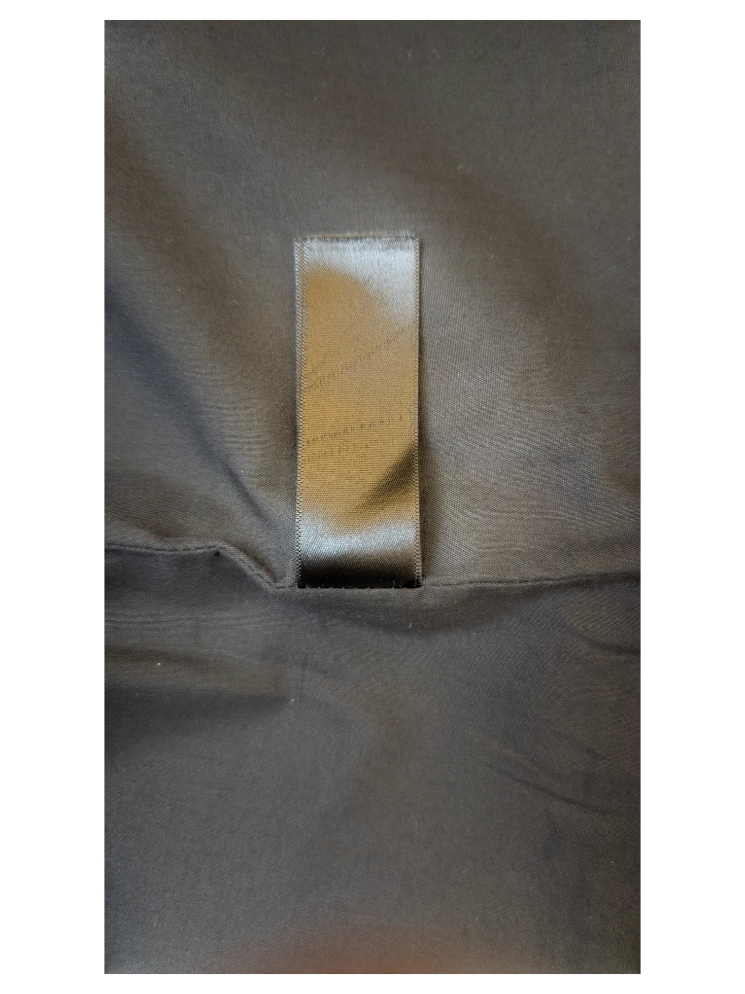 Black satin clothing label on a JAKE & IPI TOPSHOP faux leather mini skirt interior lining.