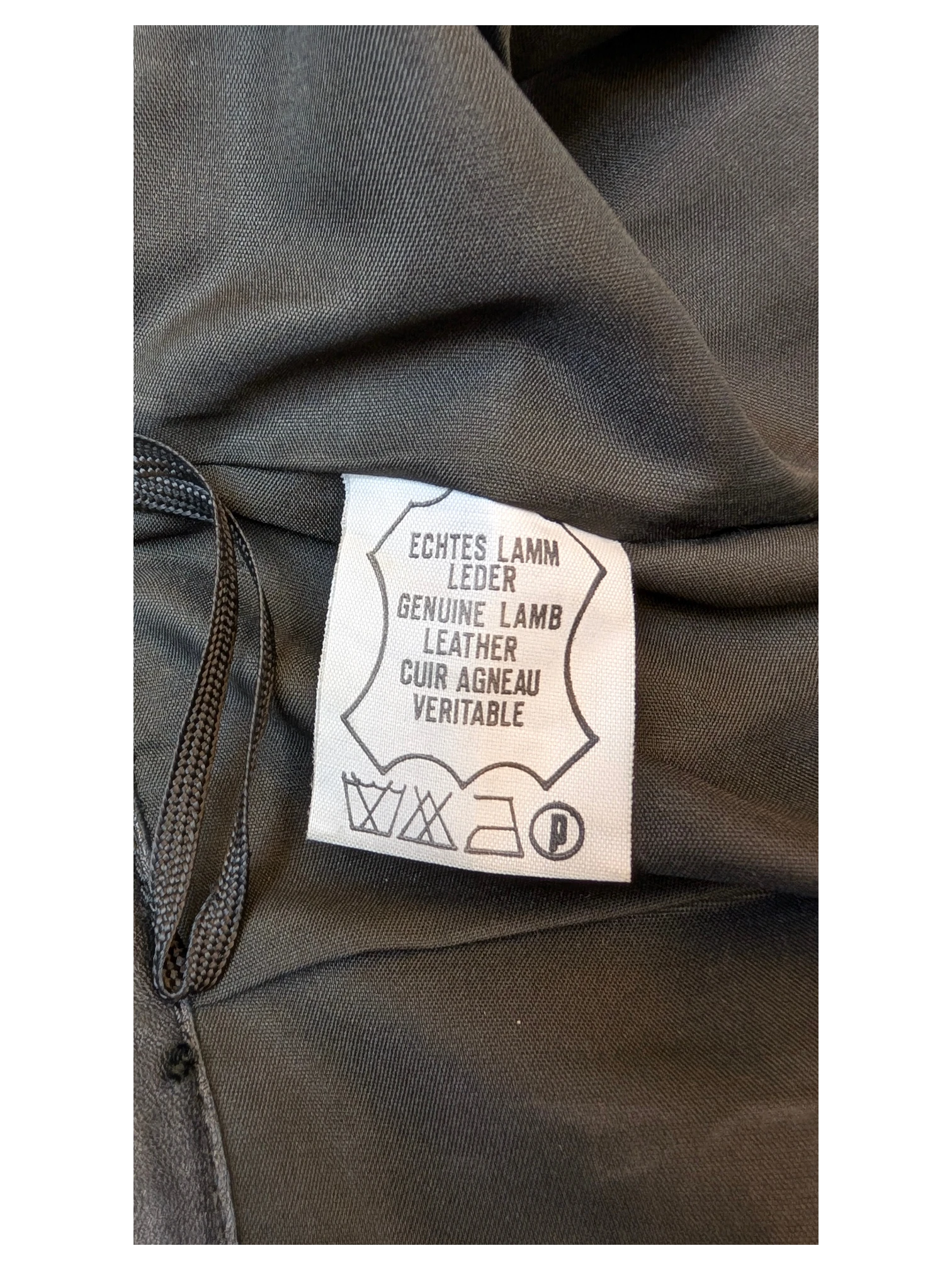 JAKE & IPI Vivien Caron genuine black lamb leather skirt care label with fabric composition and washing instructions.
