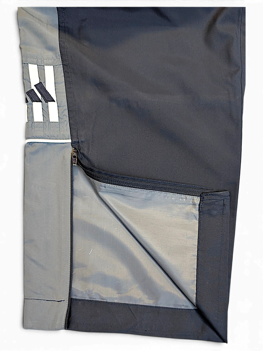 JAKE & IPI pre-owned adidas navy and grey track pants with contrast side panel, zipper detail, and embroidered logo.