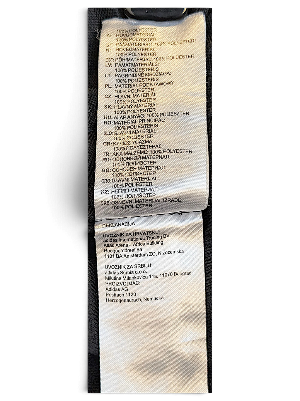 JAKE & IPI adidas track pants care label showing 100 percent polyester composition in multiple languages