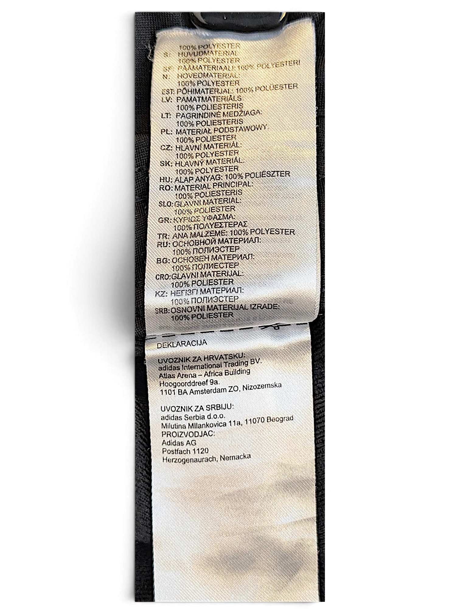 JAKE & IPI adidas track pants care label showing 100 percent polyester composition in multiple languages
