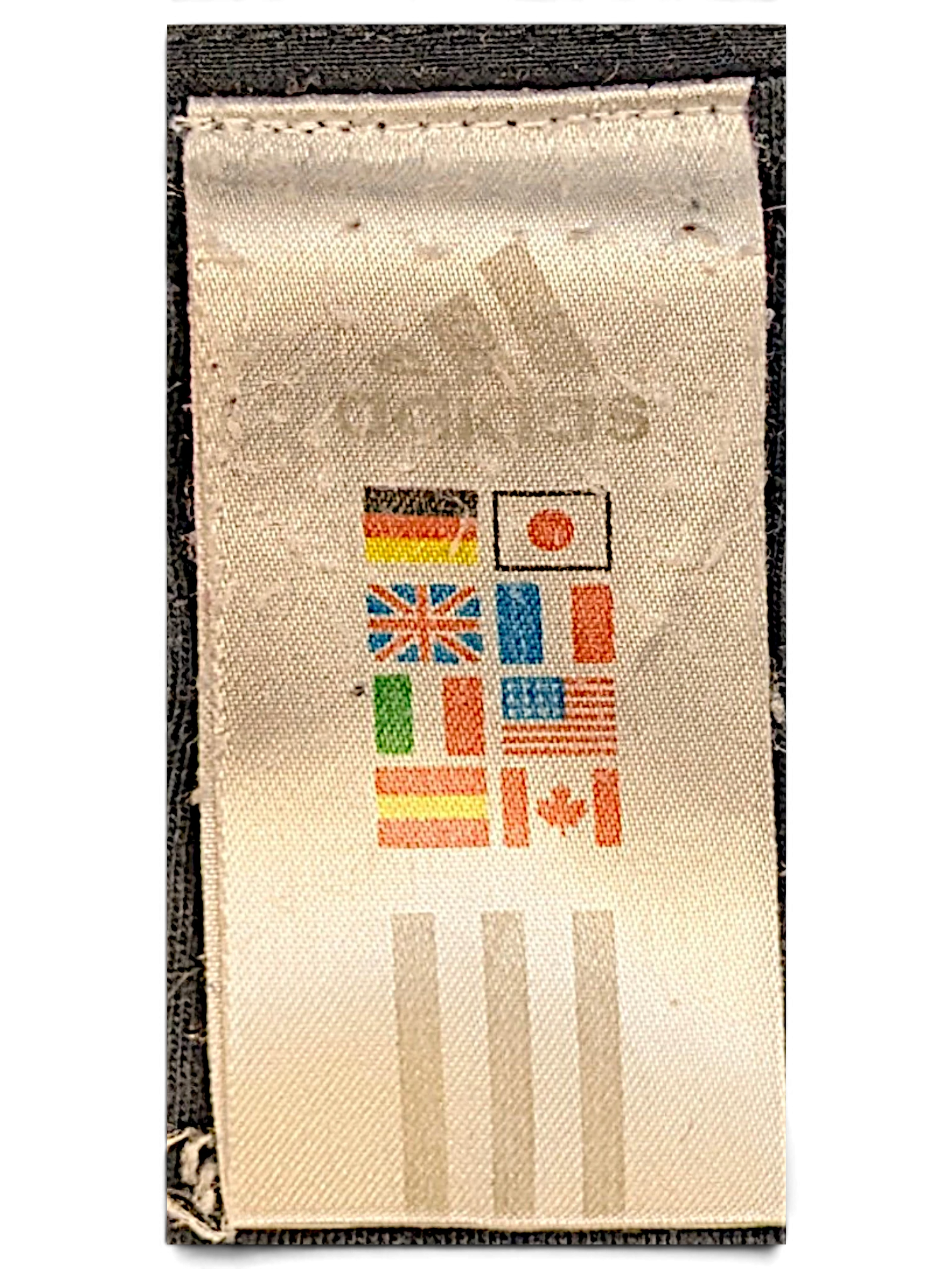 JAKE & IPI adidas track pants care label featuring the brand logo and international flag icons