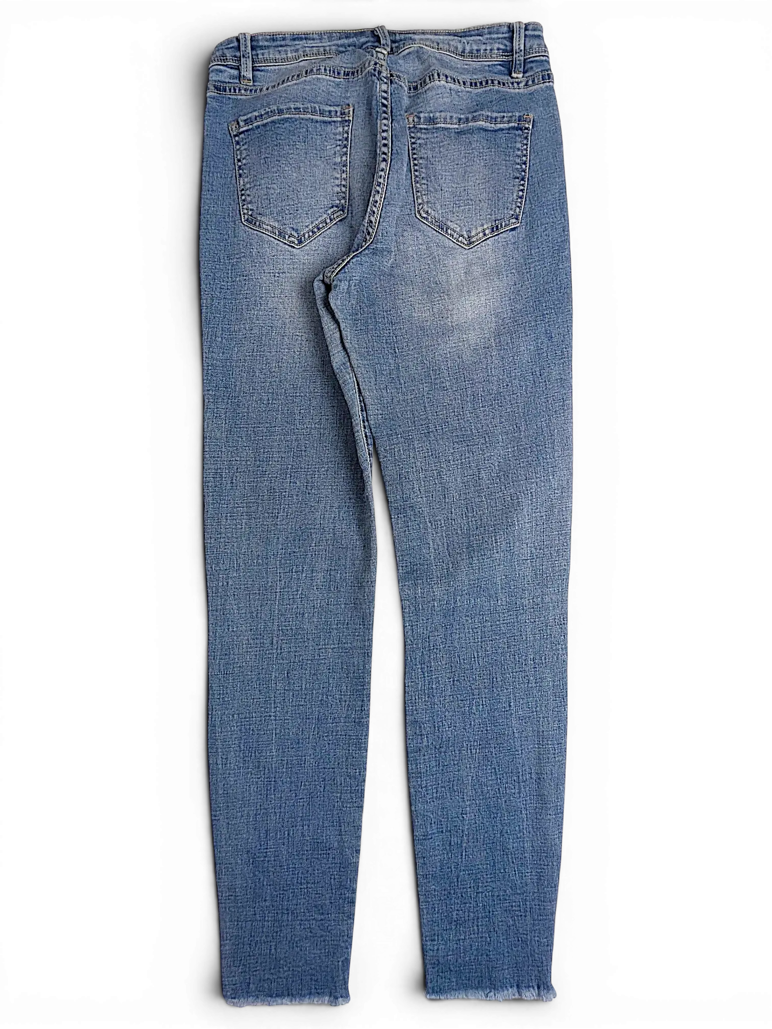 JAKE & IPI Amisu skinny jeans in light blue denim with back pockets and a raw hem, back view.